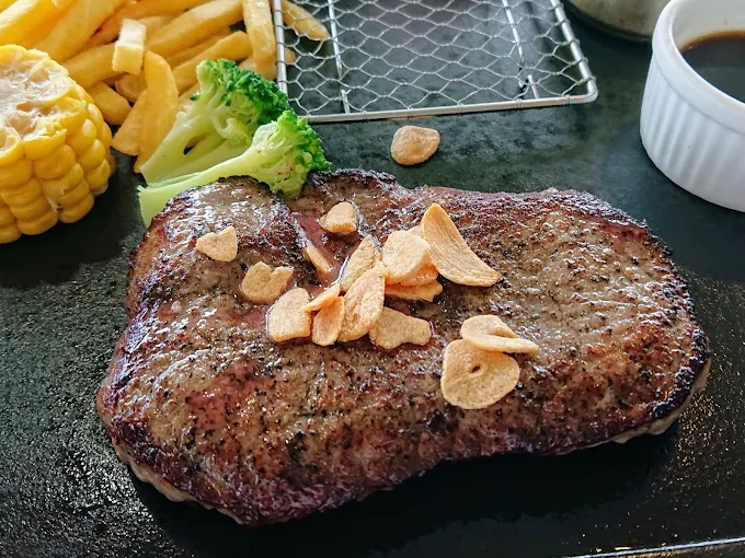 마늘칩과 채소를 곁들인 두툼한 갈릭 스테이크